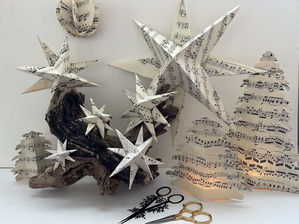 papercut Christmas ornaments by Nelly, including stars and tree shapes with lights